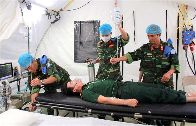 Vietnamese medical officers of the field hospital to be deployed in South Sudan are carrying out mock examination and treatment of injured patient. — VNA/VNS Photo Xuân Khu 