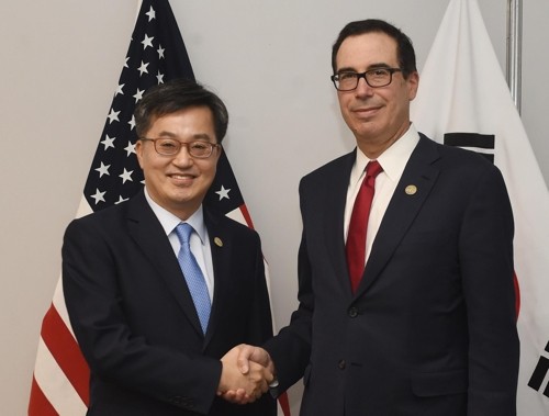 South Korea's Finance Minister Kim Dong-yeon (L) shakes hands with U.S. Secretary of the Treasury Steven Mnuchin ahead of their meeting in Buenos Aires on July 21, 2018. (Yonhap)
