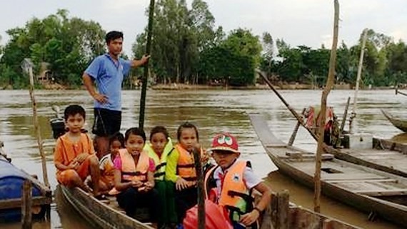 Students in An Giang province go to school on flood season Photo: SGGP