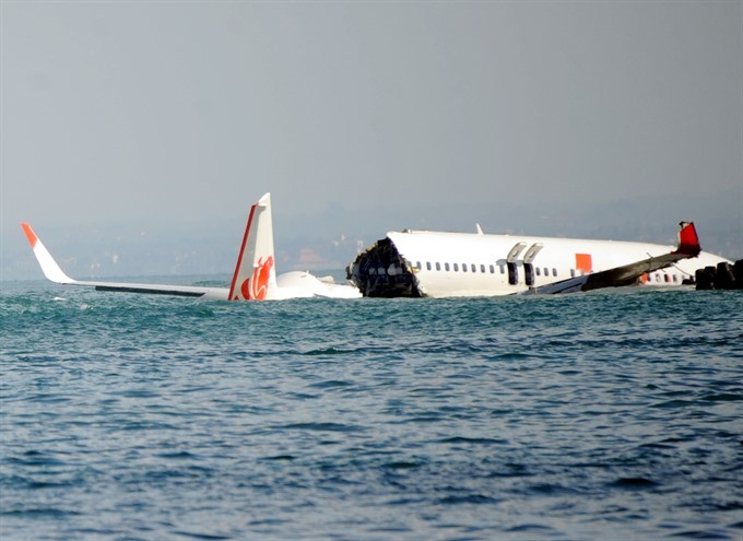 A Lion Air Boeing 737 lies submerged in the water after missing the runaway during landing at Bali’s international airport near Denpasar on April 14, 2013. Local authorities confirmed that flight JT610 departed the airport near the capital Jakarta on sche