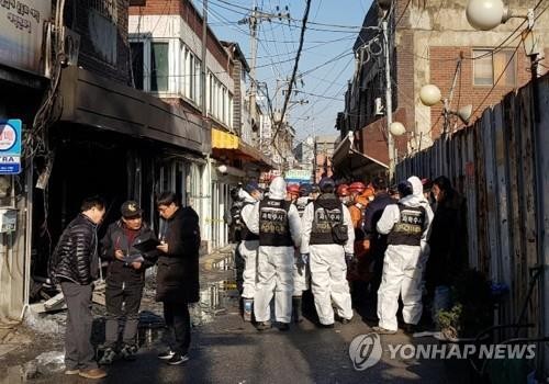 A forensic team and police officers work to process the scene of the fire in a brothel in Seoul's eastern Gangdong district that left one woman killed and severely wounded three others on Dec. 22, 2018. 