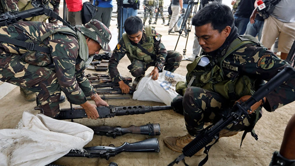 binh sĩ Philippines tịch thu vũ khí nhóm Maute bỏ lại sau đợt giao tranh. Ảnh: Reuters