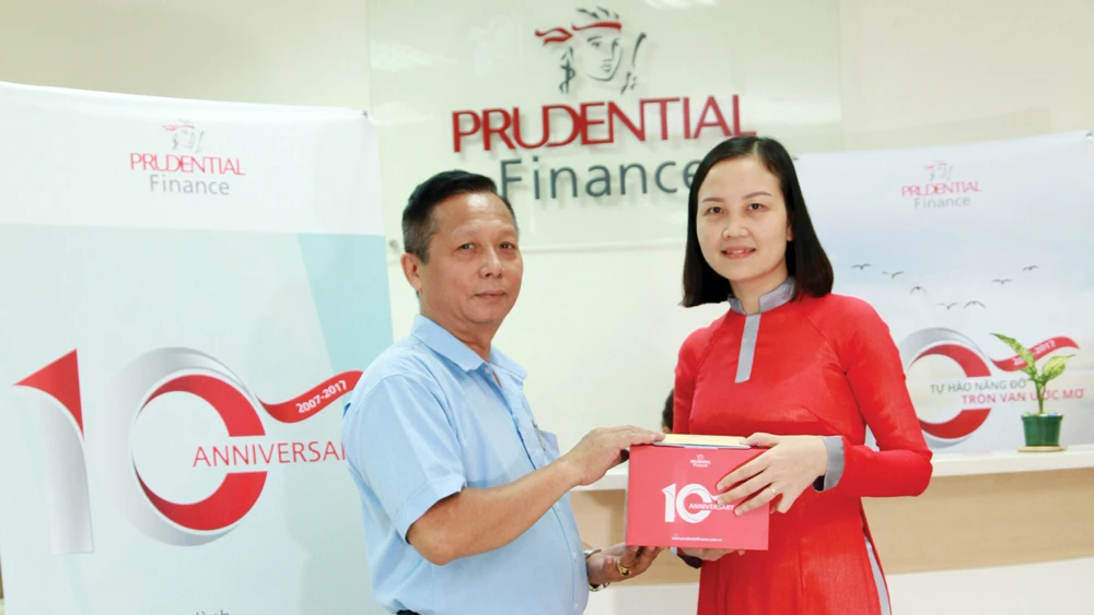 Một khách hàng có khoản vay tín chấp mới vui vẻ đón nhận quà tặng đặc biệt từ Công ty Tài chính Prudential Việt Nam nhân sự kiện kỷ niệm 10 năm thành lập