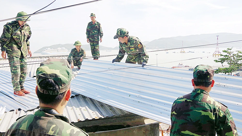 Bộ đội Biên phòng Khánh Hòa giúp dân sửa nhà. Ảnh: VĂN NGỌC