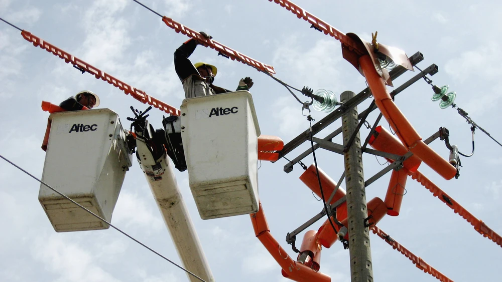 Công nhân thi công trên đường dây đang mang điện