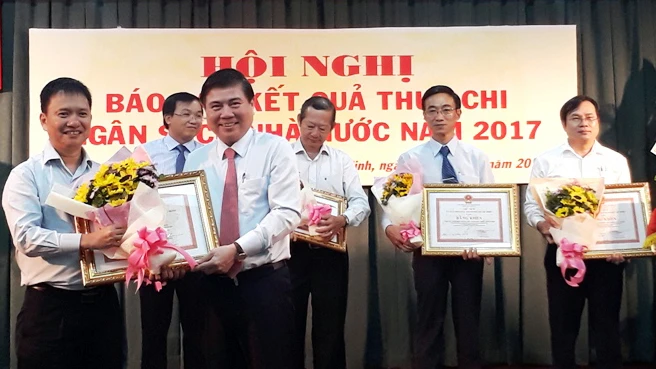 Ông Nguyễn Thành Phong, Chủ tịch UBND TPHCM trao bằng khen của Thành phố cho các đơn vị có đóng góp lớn vào nguồn thu ngân sách. Ảnh:VGP