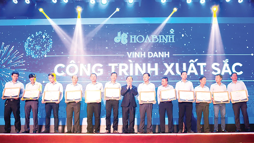 Ông Lê Viết Hải - Chủ tịch HĐQT kiêm Tổng Giám đốc Tập đoàn Xây dựng Hòa Bình (chính giữa) trao thưởng cho tập thể, cá nhân xuất sắc