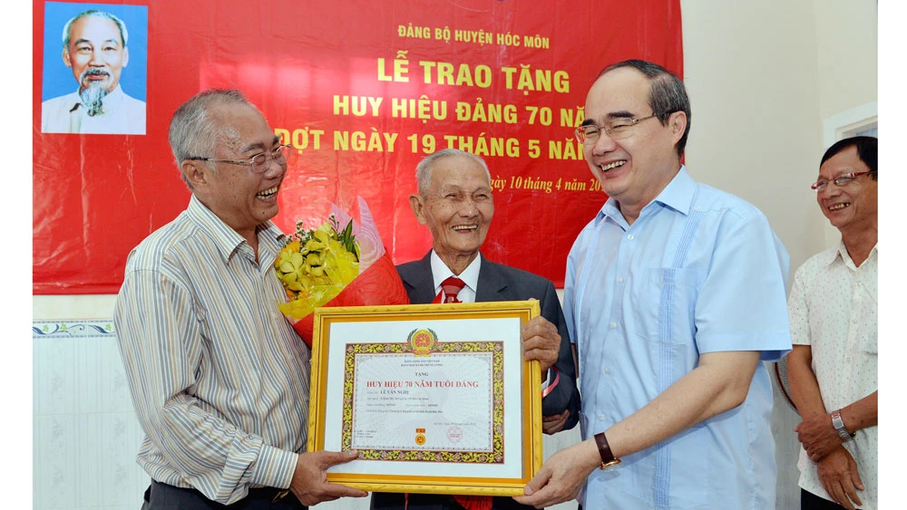 Bí thư Thành ủy TPHCM Nguyễn Thiện Nhân trao Huy hiệu 70 năm tuổi Đảng cho đồng chí Lê Văn Nghị. Ảnh: VIỆT DŨNG