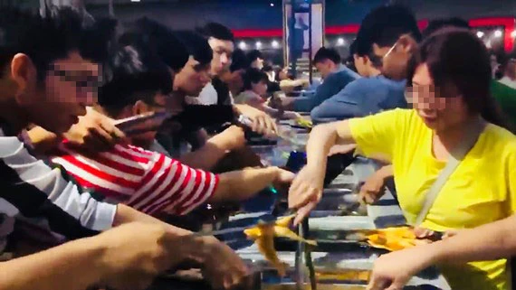 Giới trẻ tranh giành nhau gắp thức ăn tại tiệc buffet miễn phí ở Cần Thơ (ảnh cắt từ clip)