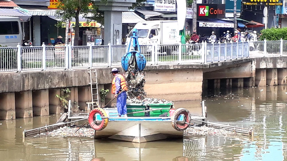 Công nhân vớt rác dưới kênh