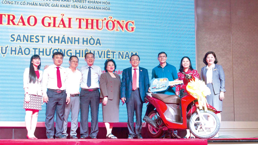 Ông Lê Hữu Hoàng - Chủ tịch Hội đồng Thành viên (mặc áo vét) cùng Ban Tổng Giám đốc Công ty Yến sào Khánh Hòa trao thưởng cho Anh Đậu Đình Phú (TPHCM) - người may mắn trúng giải thưởng 1 chiếc xe máy hiệu Honda Vision trong chương trình