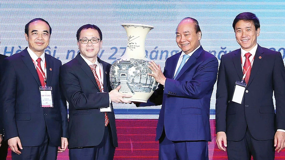Thủ tướng Nguyễn Xuân Phúc trao quà lưu niệm tặng Trường Đại học Y Hà Nội. Ảnh: TTXVN