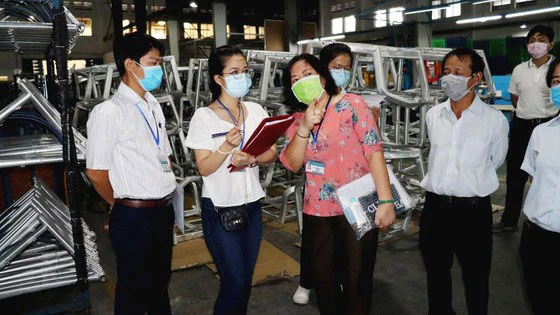 Đoàn UBND quận 7 và Trung tâm Kiểm soát bệnh tật TPHCM giám sát tại Công ty TNHH Always (KCX Tân Thuận, TPHCM). Ảnh: THÁI PHƯƠNG