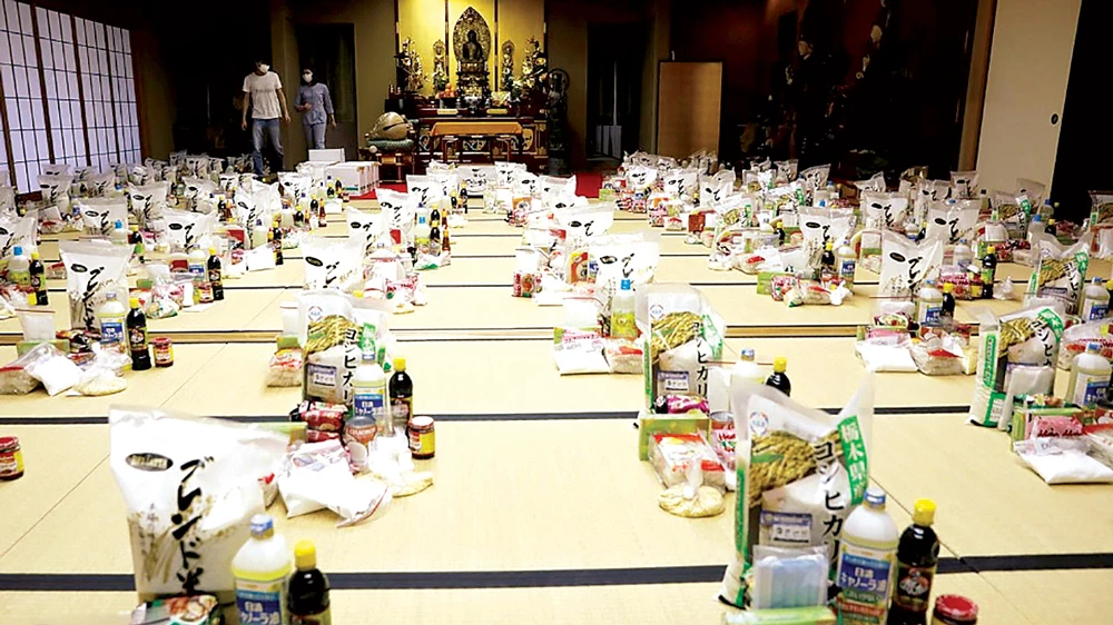 Các tình nguyện viên chuẩn bị nhu yếu phẩm cho người đến tá túc ở chùa Nisshinkutsu. Ảnh: Reuters