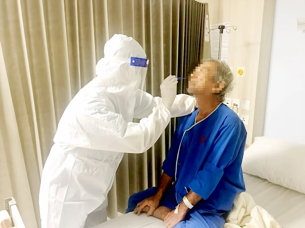 Nhân viên Bệnh viện Gia An 115 lẫy mẫu xét nghiệm sàng lọc SARS-CoV-2 cho người bệnh vào đêm 12-5