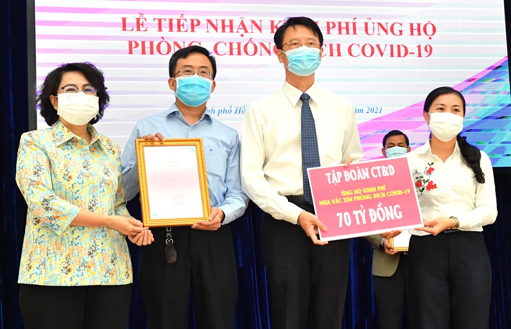 Chủ tịch Ủy ban MTTQ Việt Nam TPHCM Tô Thị Bích Châu (trái) tiếp nhận đóng góp của tập đoàn CT&D ủng hộ kinh phí mua vaccine phòng chống dịch Covid-19. Ảnh: VIỆT DŨNG