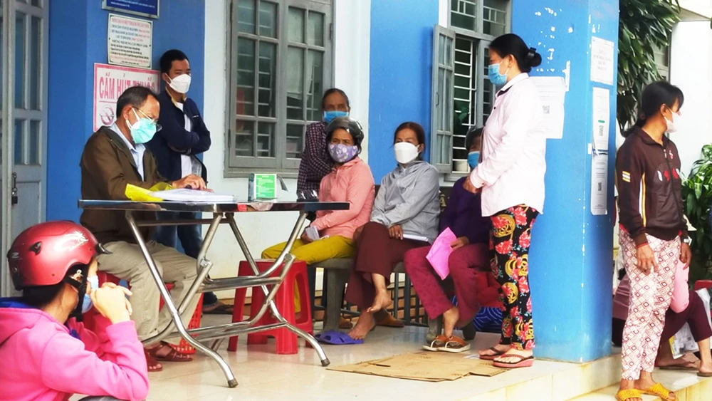 Người dân phường Hoài Xuân, thị xã Hoài Nhơn, Bình Định đến trạm y tế nộp tiền test Covid-19 vào chiều 29-12 để được tiêm vaccine