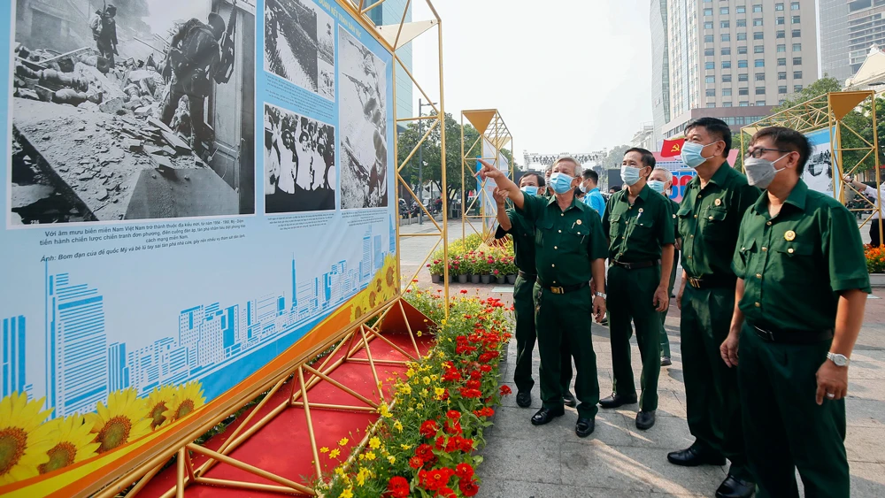 Các đại biểu xem triển lãm “Thành phố Hồ Chí Minh - 47 năm cùng cả nước, vì cả nước”. Ảnh: DŨNG PHƯƠNG
