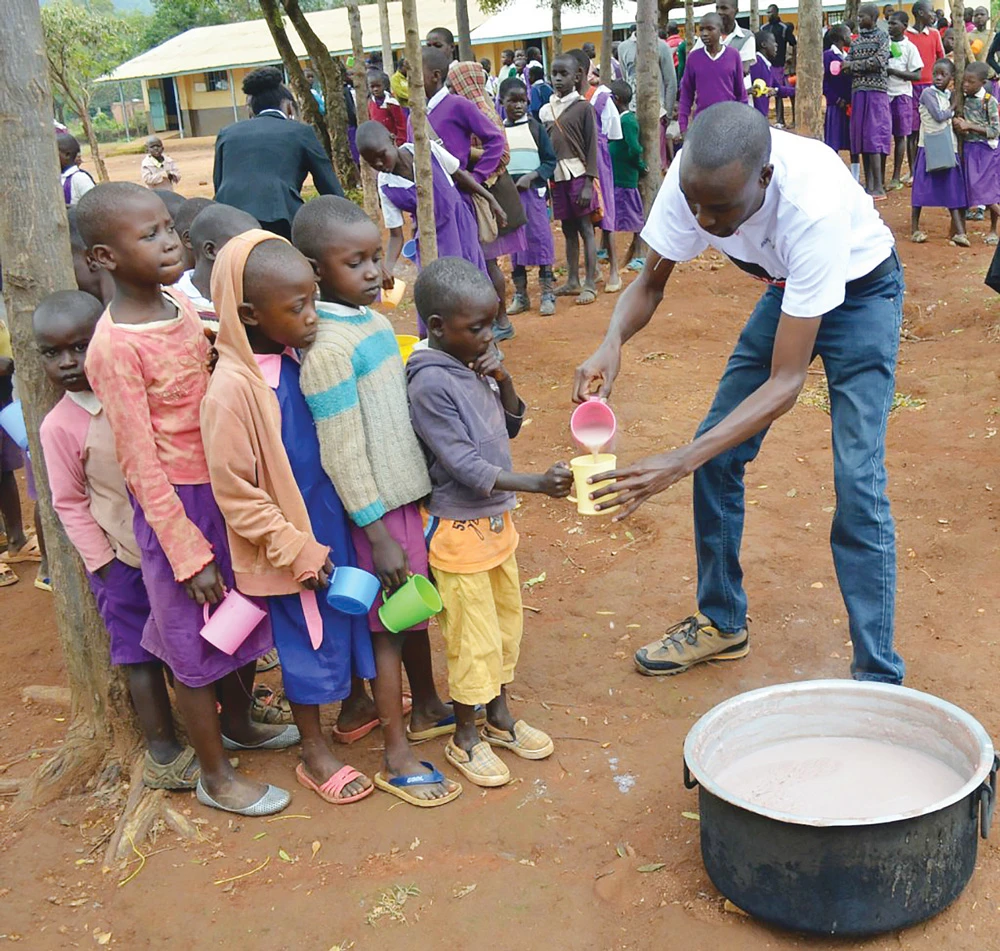 Trẻ em một trường học ở Kenya xếp hàng lấy cháo dinh dưỡng