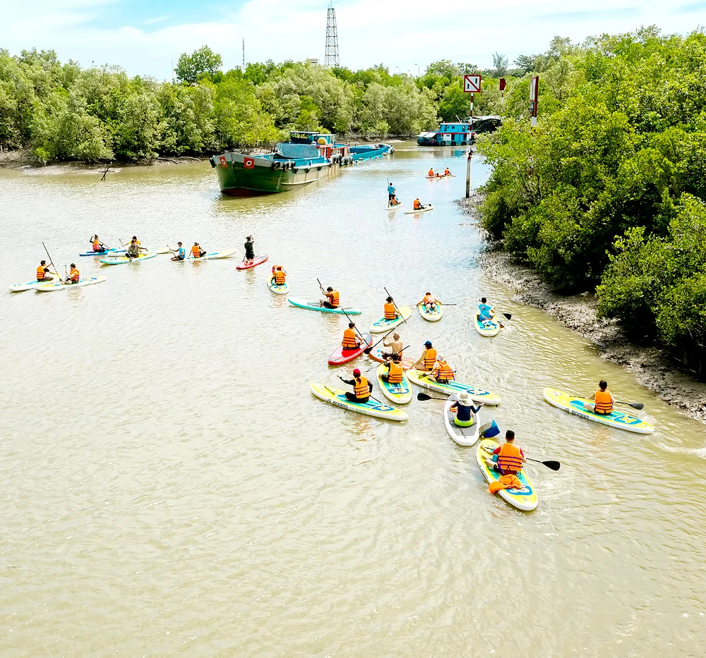 Du khách chèo SUP tại huyện Cần Giờ, TPHCM. Ảnh: THI HỒNG