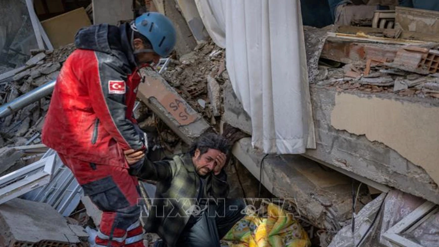Nhân viên cứu hộ giải cứu anh trai ra khỏi đống đổ nát sau trận động đất ở Hatay, Thổ Nhĩ Kỳ, ngày 8-2-2023. Ảnh: TTXVN