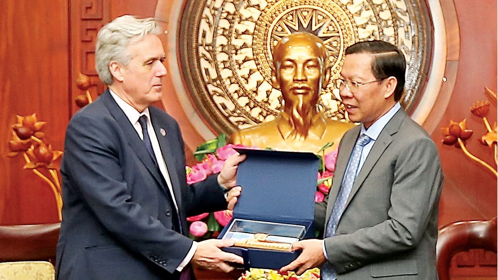 Chủ tịch UBND TPHCM Phan Văn Mãi tặng quà lưu niệm ông Mark Garnier, Đặc phái viên của Thủ tướng Anh tại Thái Lan, Myanmar, Brunei và Việt Nam. Ảnh: DŨNG PHƯƠNG