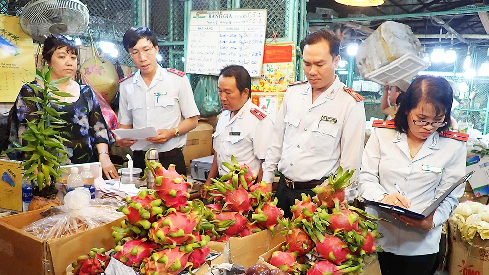 Lực lượng chức năng kiểm tra an toàn thực phẩm tại chợ đầu mối nông sản Thủ Đức. Ảnh: HOÀNG HÙNG