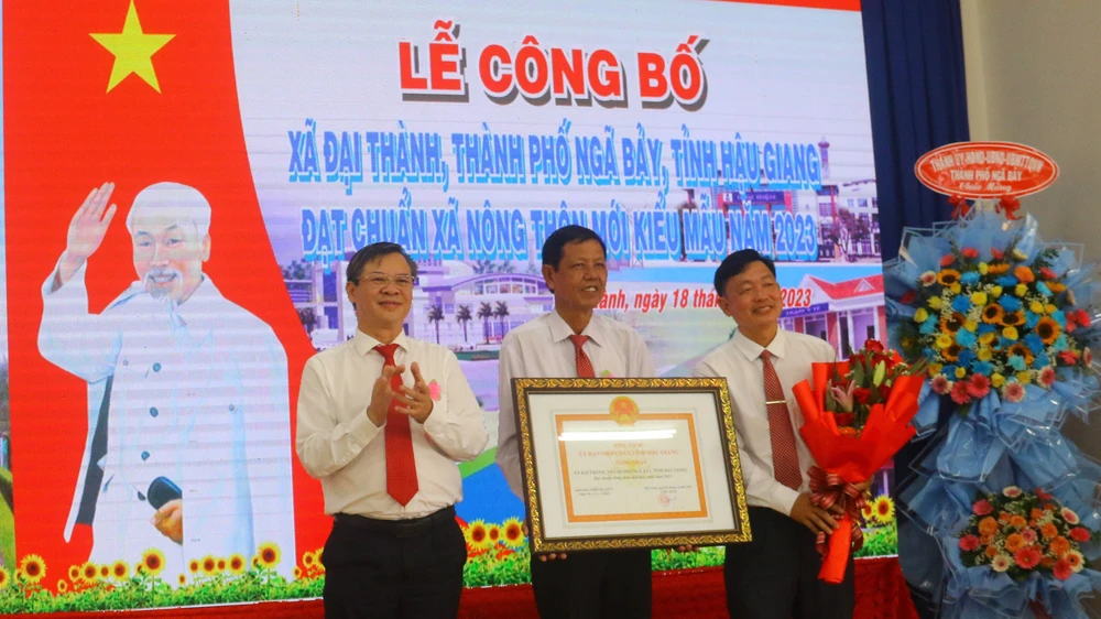 Ông Trương Cảnh Tuyên (bìa trái), Phó Chủ tịch Thường trực UBND tỉnh Hậu Giang trao bằng công nhận xã nông thôn mới kiểu mẫu cho lãnh đạo xã Đại Thành