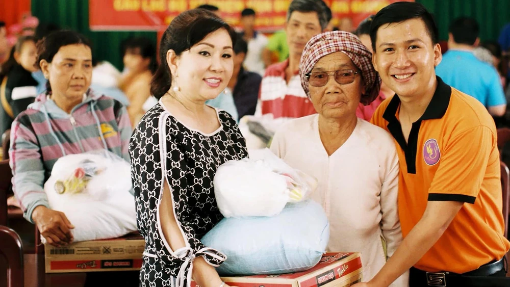 Chị Thái Thị Ngọc Phú (thứ 2, từ trái qua) tặng quà cho người nghèo