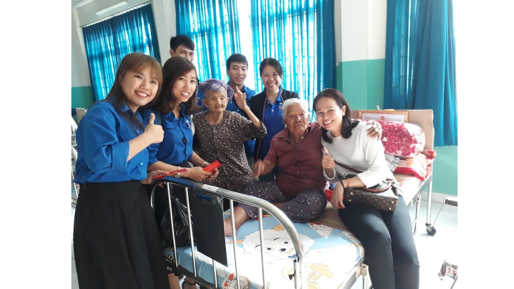 Đoàn công tác của Báo SGGP đến từng giường lì xì mừng tuổi các cụ ở Trung tâm Nuôi dưỡng bảo trợ người bại liệt Thạnh Lộc