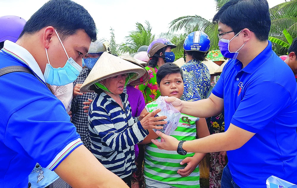 Các bạn trẻ tham gia phát khẩu trang, nước rửa tay sát khuẩn, sổ tay tuyên truyền phòng chống dịch Covid-19 cho bà con xã Thạnh Phú Đông, huyện Giồng Trôm, tỉnh Bến Tre