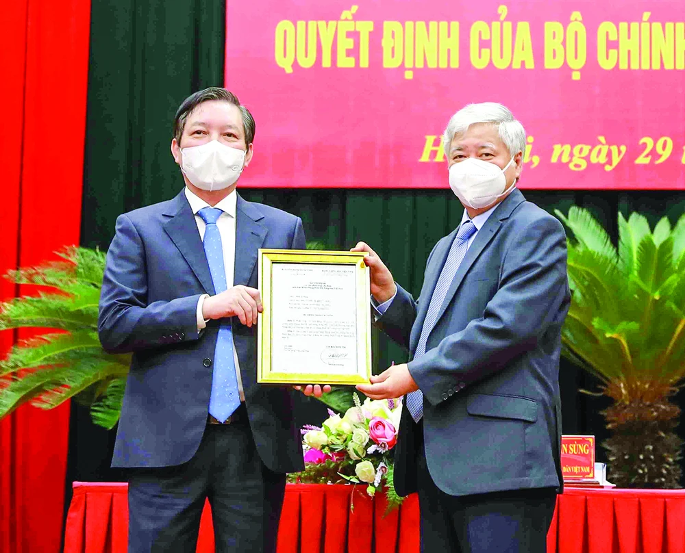 Chủ tịch Ủy ban Trung ương MTTQ Việt Nam Đỗ Văn Chiến (phải) trao quyết định cho đồng chí Lương Quốc Đoàn. Ảnh: TTXVN