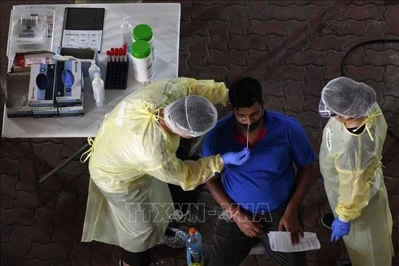 Nhân viên y tế lấy mẫu xét nghiệm Covid-19 cho người dân tại Singapore. Ảnh: TTXVN