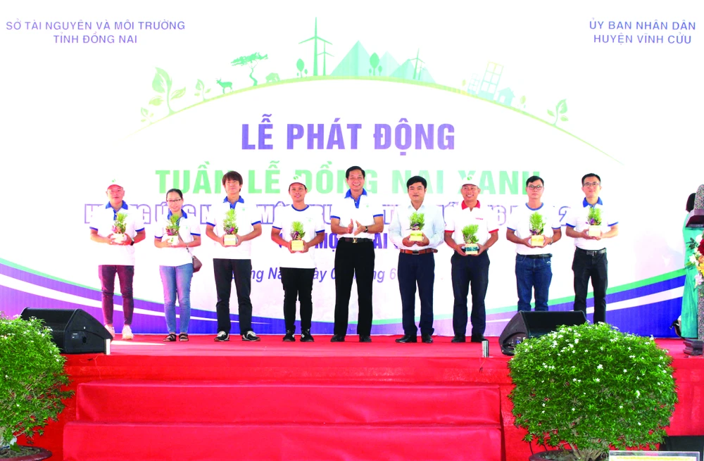 Ông Huỳnh Tấn Lộc (thứ ba từ phải qua) - đại diện Vedan Việt Nam - đang nhận những phần quà là cây xanh từ Ban tổ chức chương trình