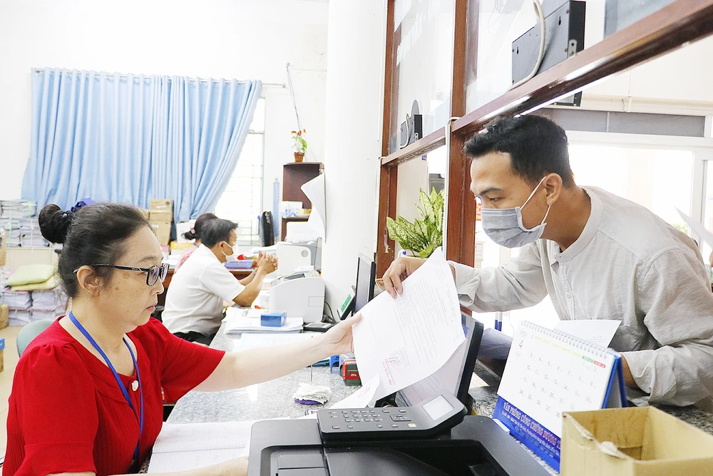 Công chức phường Bình Hưng Hòa A, quận Bình Tân, TPHCM tiếp nhận giải quyết thủ tục hành chính cho người dân. Ảnh: NGÔ BÌNH