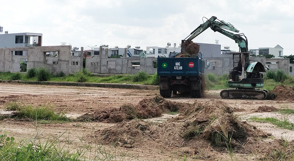 Công trình chợ tại khu TĐC Lộc An - Bình Sơn chỉ có 1 xe san gạt, múc đất trên công trường