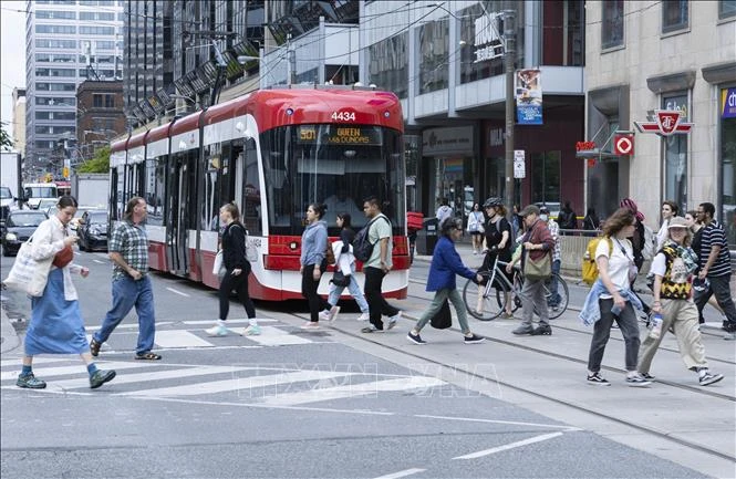 Người dân di chuyển trên đường phố tại Toronto, Ontario, Canada. Ảnh: THX/TTXVN