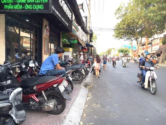 Mặc dù vỉa hè đường Nguyễn Thị Minh Khai (phường Đa Kao, quận 1) chỉ rộng hơn 1m nhưng các quán cà phê vẫn chiếm hết diện tích làm chỗ đậu xe máy, đẩy người đi bộ xuống lòng đường