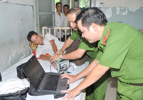  Trung tá Nguyễn Văn Trường (phải) cùng đồng nghiệp đến Bệnh viện Ung Bướu, quận Bình Thạnh làm thẻ căn cước cho ông Nguyễn Hữu Nghĩa