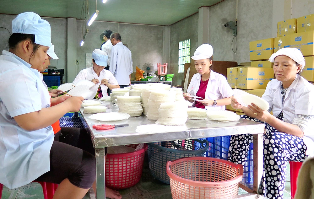 Lao động nông thôn làm việc trong một hợp tác xã sản xuất bánh tráng ở huyện Củ Chi
