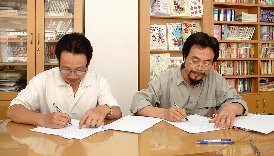 Đại diện NXB Kim Đồng (phải) ký hợp đồng ưu tiên với gia đình nhà văn Xuân Sách