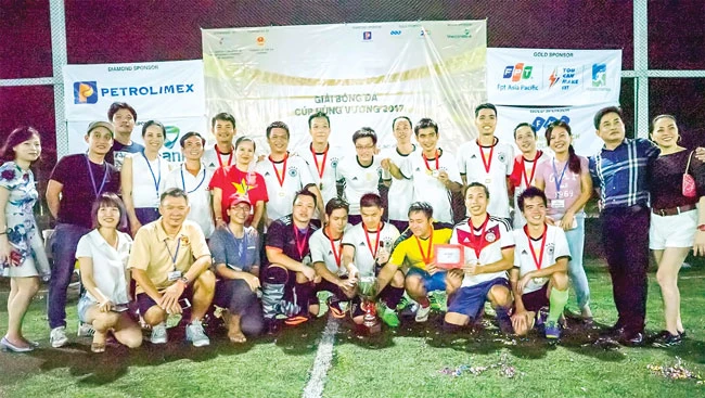 Tác giả Lê Hữu Huy (ngồi hàng đầu, thứ hai trái sang) trong vai trò Ban Tổ chức vòng chung kết Cúp bóng đá Hùng vương tại Singapore trung tuần tháng 4-2017.