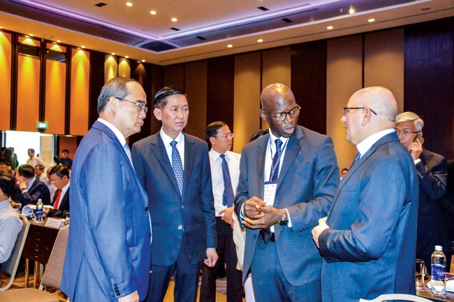 Bí thư Thành ủy TPHCM Nguyễn Thiện Nhân trao đổi với các nhà đầu tư nước ngoài bên lề hội thảo. Ảnh: ĐỨC TRUNG