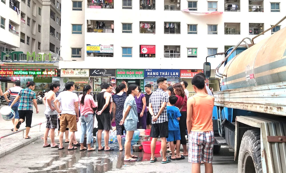 Người dân tại nhiều khu vực ở Hà Nội phải xếp hàng chờ lấy nước từ xe bồn vì nước sạch sông Đà nhiễm mùi lạ. Ảnh: QUỐC KHÁNH