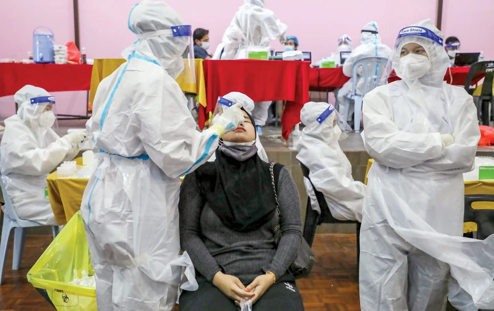 Nhân viên y tế lấy mẫu xét nghiệm Covid-19 cho người dân tại Jakarta, Indonesia. Ảnh: AFP