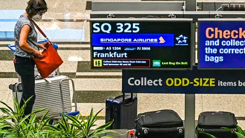 Một hành khách trên chuyến bay SQ325 của Singapore Airlines - chuyến bay đầu tiên đến Singapore theo VTL trong sảnh hành lý tại sân bay Changi ngày 8-9-2021.