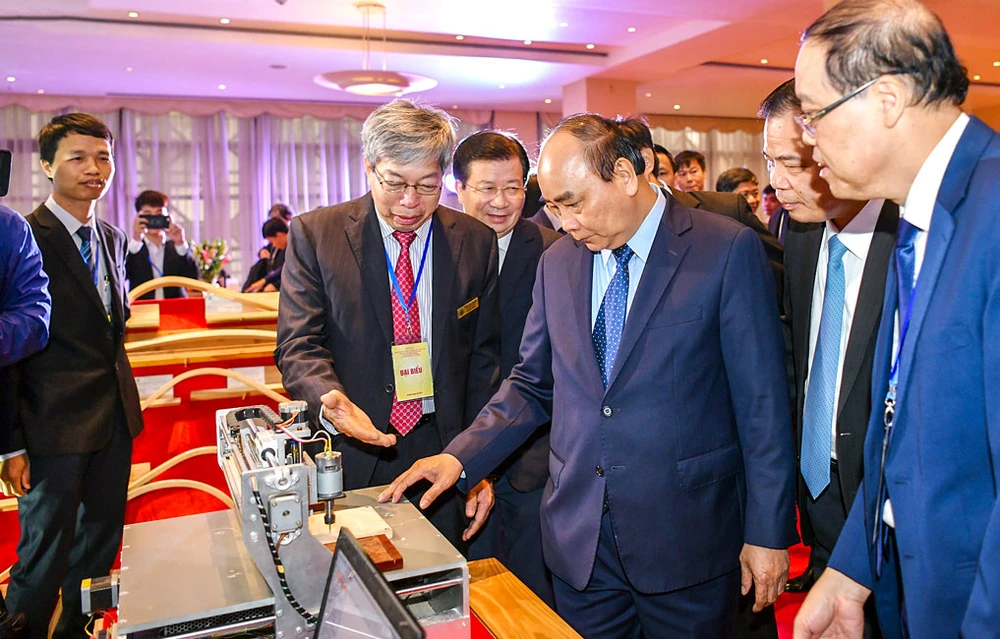 Khi còn nhiệm kỳ Thủ tướng, Chủ tịch nước Nguyễn Xuân Phúc đã đến thăm một DN giới thiệu về công nghệ chế biến gỗ xuất khẩu. Ảnh: QUANG HIẾU