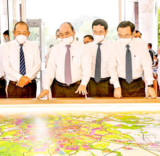 President Nguyen Xuan Phuc (2nd from left), Secretary of the HCMC Party Committee Nguyen Van Nen (right), Minister of Information and Communications Nguyen Manh Hung (2nd from right) and former Deputy Prime Minister Truong Hoa Binh (left) look at the Nort