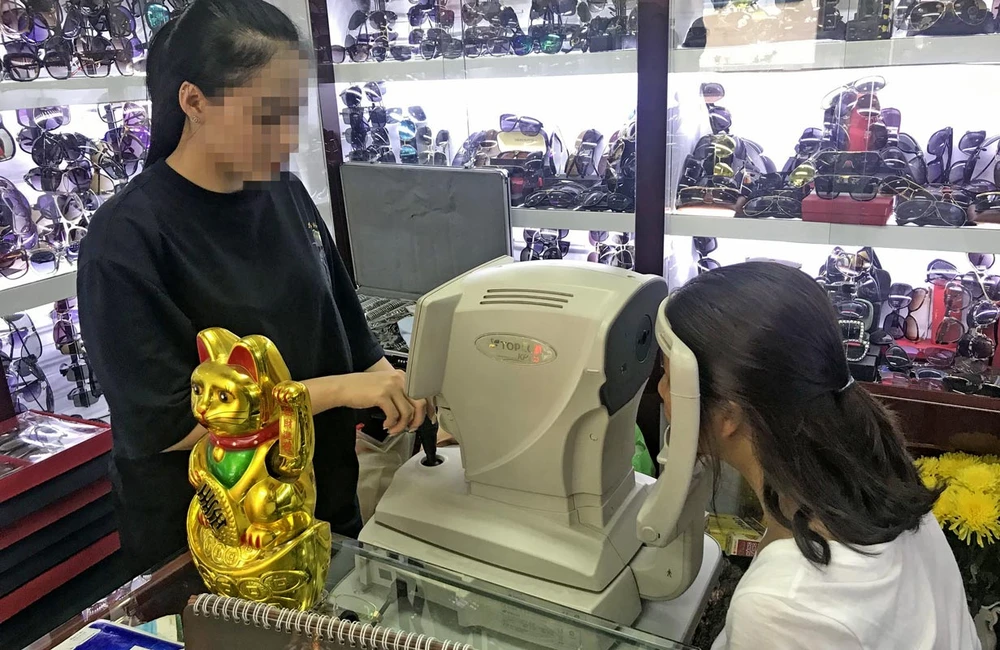 Kỹ thuật viên đo độ cận của mắt cho khách hàng tại một cửa hàng kính thuốc ở TPHCM Ảnh: HOÀNG HÙNG