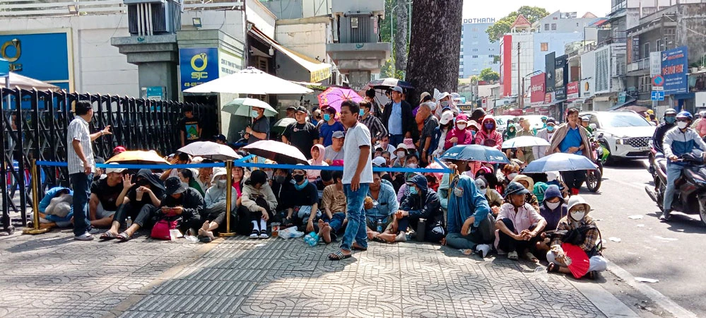 Liệu có "bàn tay" đứng sau nhờ mua hộ vàng không, bởi với cái nắng như thiêu đốt giữa mùa hè, những "nhà đầu tư" này vẫn chờ đợi ngày này sang ngày khác để được bốc số mua vàng. Ảnh: ĐÌNH DƯ